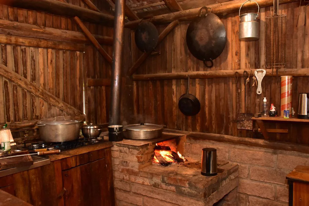 Cozinha rústica da Aldeia com fogão a lenha aceso