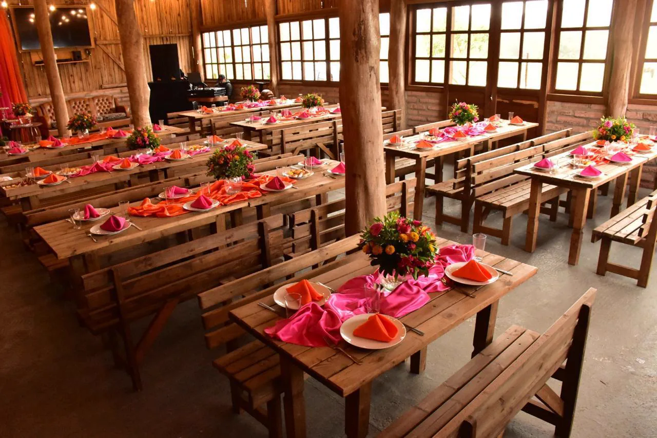 Salão da Aldeia decorado com flores e mesas prontas para um evento